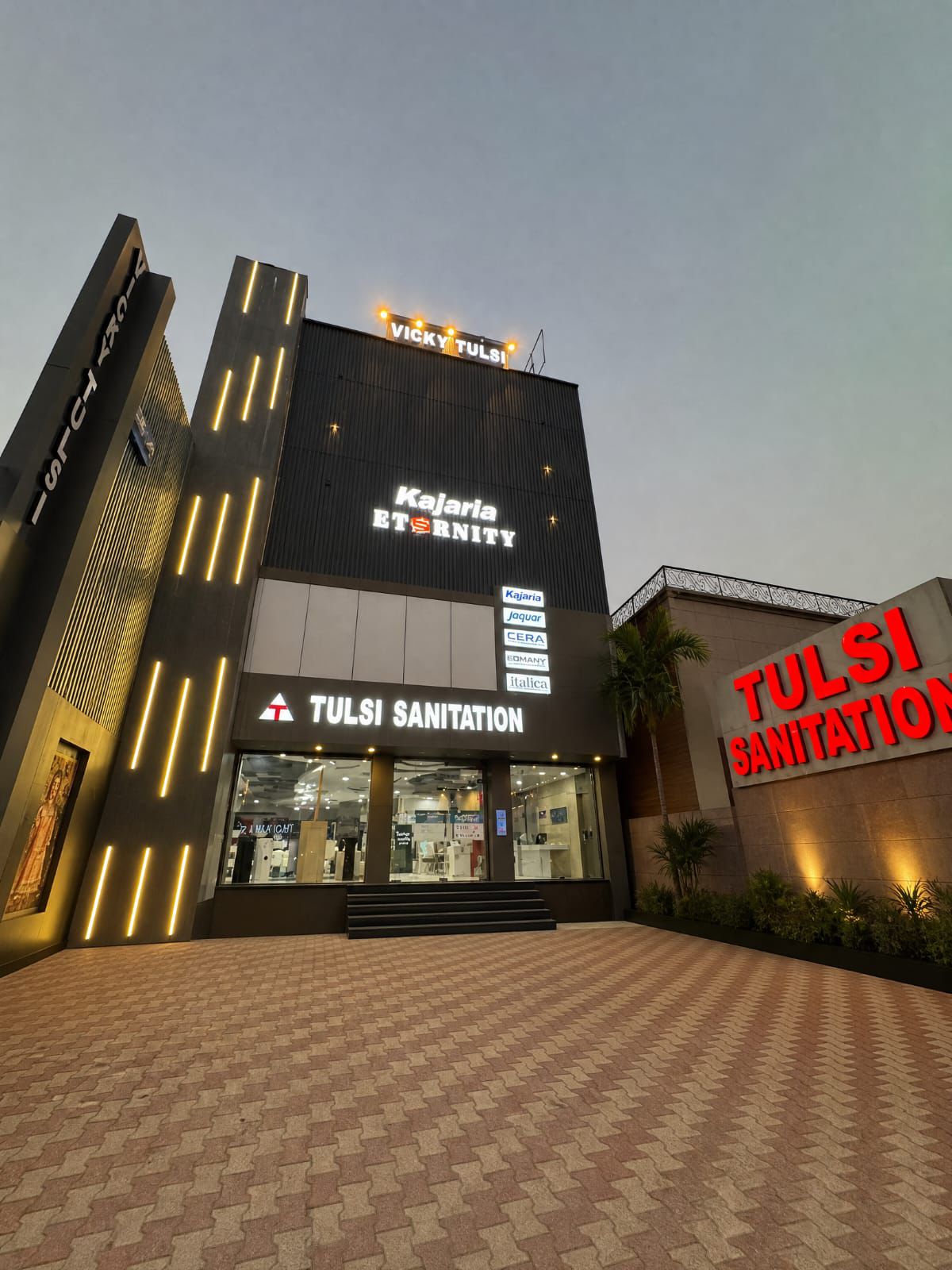 Tulsi Sanitation showroom building lit at dusk